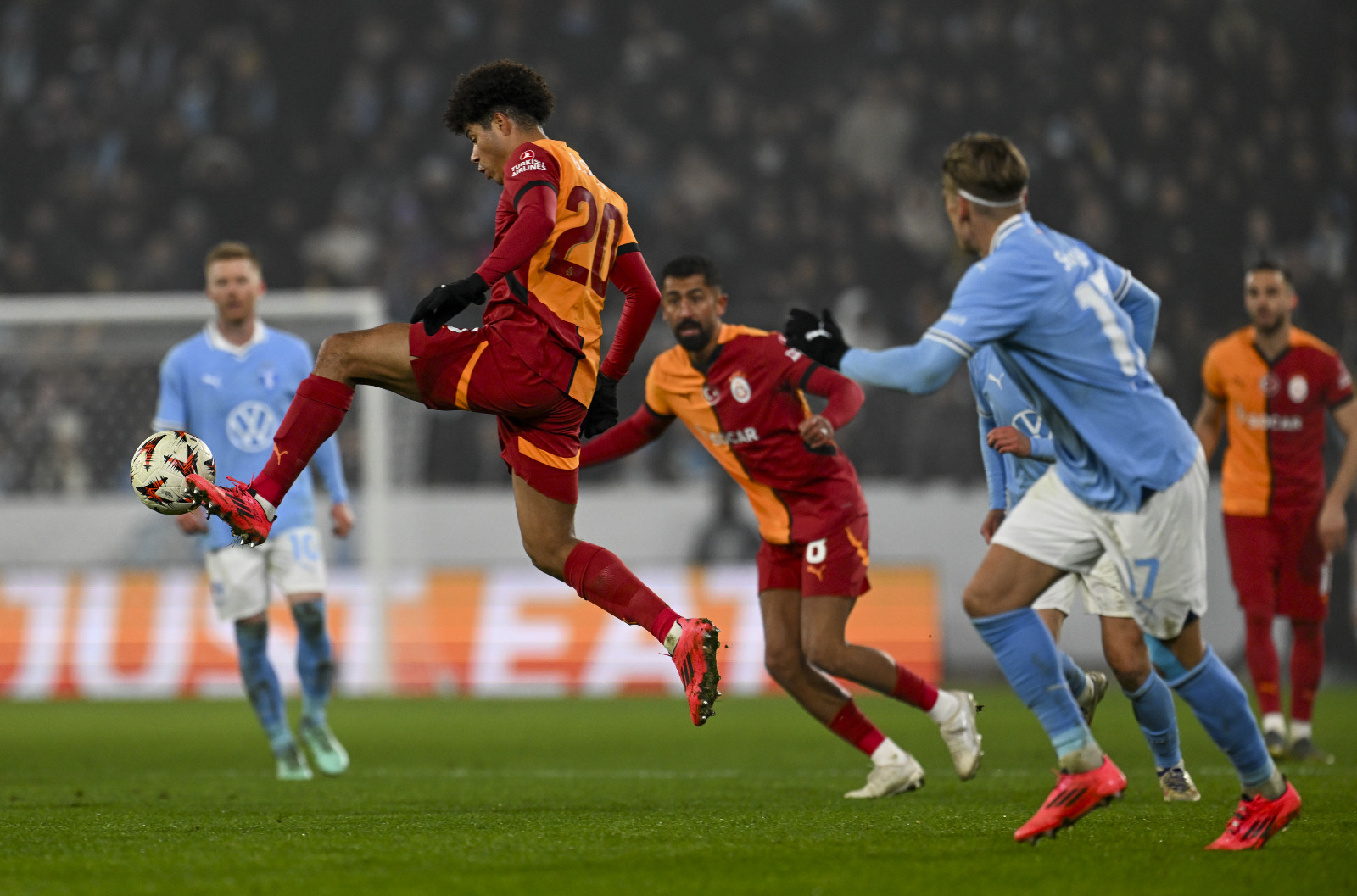 Mustafa Ersoy: Hava Sivas'tan soğuk, rakip Sivas'tan çok daha iyi ama şanssızlık yine Sarı-Kırmızılı formanın peşinde. Hücumda her türlü alternatifi üreten Galatasaray bu sezon en çok arıza çıkan bölge olan savunmada bu kez Davinson Sanchez'i kaybetti. 30. dakikada Sanchez de oyundan çıkınca oyun kurgusu yine değişti. Okan Buruk yine şapkadan bir tavşan çıkarttı. Özlemle oynamayı bekleyen Kerem Demirbay'ı oyuna aldı. Kerem'in asisti, acabalarla dolu Jelert'in ilk golüne kavuşmasına neden oldu. Yedek kulübesinden gelmesine alışık olduğumuz Batsuhayi'yi bir anlamda işini yaptı. Çünkü atılan 2 gol de onun boşalttığı alanlardan geldi. Ama İcardi yok, Osimhen yok top sende. Bir gol çok şey değiştirirdi. Bir topa da dokun be arkadaş. Neyse istemek kolay. Bazen olmuyor. Batsuhayi'ye gelene kadar, yedek kulübesinin rahat ve sıcak koltuğundan kalkmak bile istemeyen Nelson'a neler söylemeli? Bunca beklenmedik gelişme içinde Galatasaray, İsveç'ten 1 puanla dönüp Avrupa Ligi'nde ilk 8 için avantajını sürdürüyorsa bu genetik bir durum olmalı. Yazının başında belirttiğim gibi U-19 takımından 3 genç kulübü kuruluş amacınına yakından tanık olurken, Efe Akman ilk kez Avrupa'da forma giydi, Jelert kabuğunu kırdı ve özgüvenine yeniden kavuştu. Sivas'ta olduğu gibi senarist tüm tuşlara bastı, 90 dakika içinde ne kadar olasılık varsa yaşandı. Film kötü başladı, başroldeki iyi adam ölmedi, seyirci salondan çıkarken öyle ya da böyle az da olsa mutluydu. (T24)